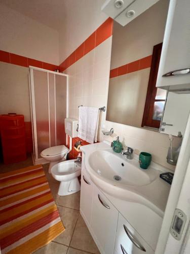 ein Badezimmer mit einem Waschbecken, einem WC und einem Spiegel in der Unterkunft SicilyBijou in Gela