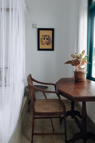 a table and chair next to a window with a plant at Lighthouse Ahangama in Ahangama