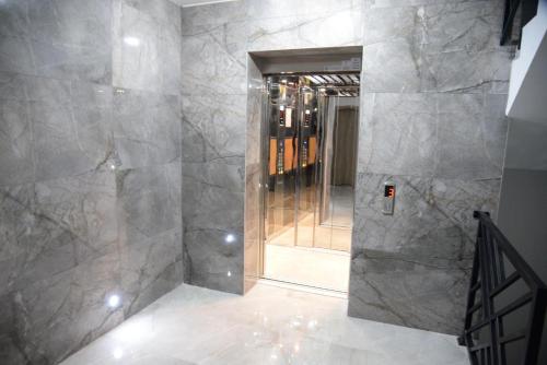 ein Bad mit einer ebenerdigen Dusche und einem Spiegel in der Unterkunft Apartment Chloee in Gevgelija