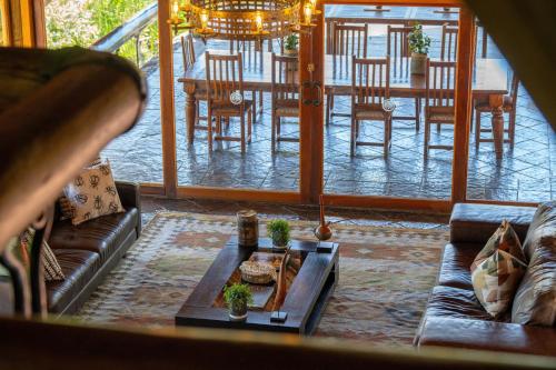 a living room with a couch and a table and chairs at Sediba Luxury Safari Lodge in Welgevonden Game Reserve