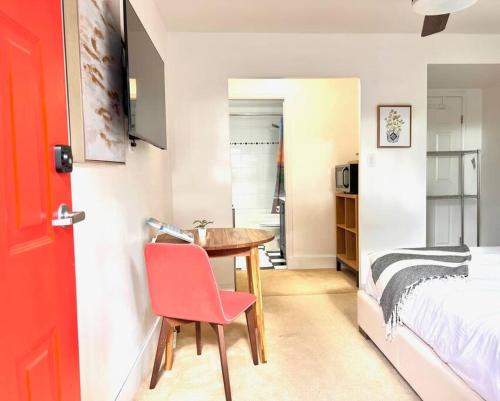 a room with a table and a bed and a red door at 'Canyon Heights' Retreat (Grouse Mountain) in North Vancouver