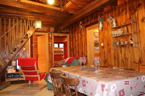 d'une salle à manger avec une table, des chaises et des murs en bois. dans l'établissement Chalet le Grand Tétras, à La Bresse