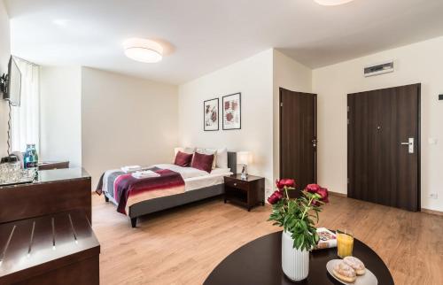een slaapkamer met een bed en een tafel in een kamer bij Rent like home - Elizy Orzeszkowej 6 in Poznań