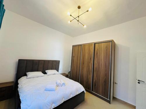 a bedroom with a large bed and a wooden cabinet at Vladi's Home in Çorovodë