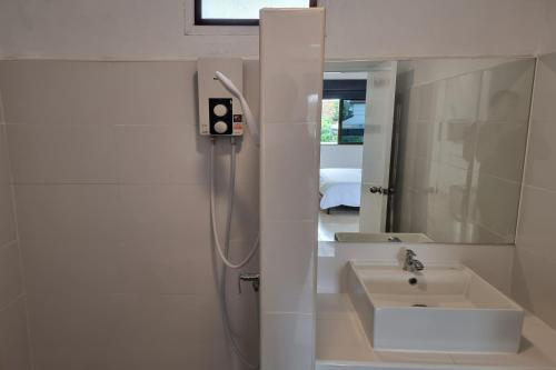 a bathroom with a sink and a shower and a mirror at Breezy Pattaya in Jomtien Beach