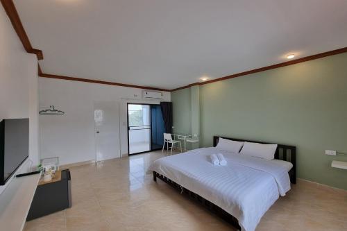 um quarto com uma grande cama branca e uma mesa em Breezy Pattaya em Praia de Jomtien