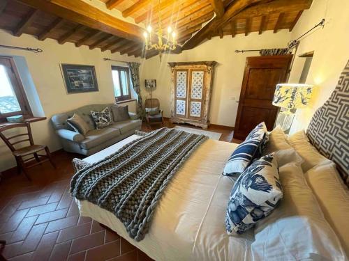 um quarto com uma cama grande e um sofá em Pevoni - 1 Bed aprtment with stunning Tuscan views em Anghiari