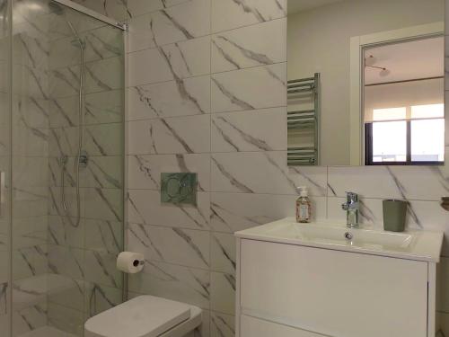 uma casa de banho com um lavatório, um WC e um espelho. em Luxe Appartement Orihuela Costa - Villamartin -Aire Residencial - green and pool view em Orihuela Costa