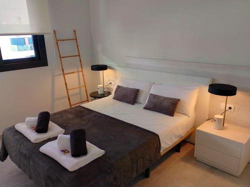 una camera da letto con un letto con due asciugamani sopra di Luxe Appartement Orihuela Costa - Villamartin -Aire Residencial - green and pool view a Orihuela Costa