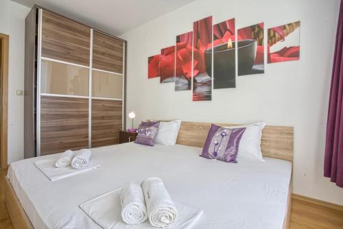 ein Schlafzimmer mit einem weißen Bett und Handtüchern darauf in der Unterkunft Lovely apartment in Aspen Golf Resort with SPA in Bansko