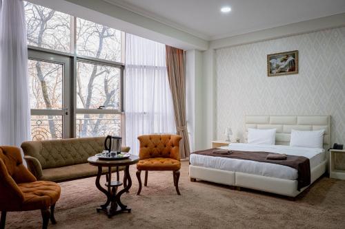 - une chambre avec un lit, un canapé et une table dans l'établissement Shahdag Quba & Truskavets, à Quba