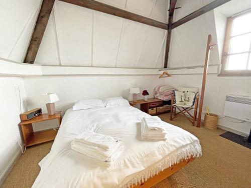 Un dormitorio con una cama blanca con toallas. en Le pigeonnier en Trémolat