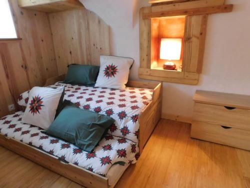 une petite chambre avec un lit et un miroir dans l'établissement Petite maison de village cosy à Serre chevalier, au Monêtier-les-Bains