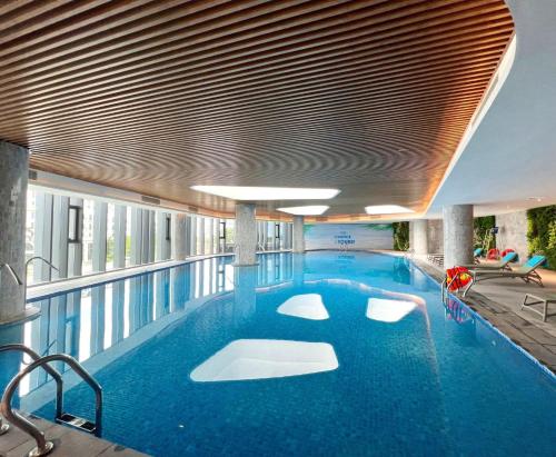 - une grande piscine d'eau bleue dans un bâtiment dans l'établissement Khách sạn A LaCarte Hạ Long - Quảng Ninh, à Hạ Long