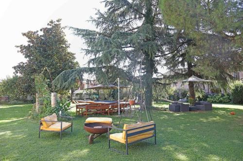 a group of chairs sitting in a yard with a table at Il Bozzolo Eco Boutique Apartments in Valeggio sul Mincio