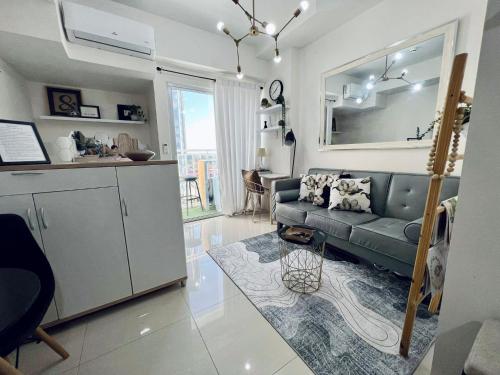 a living room with a couch and a kitchen at Inspiria Abreeza Davao in Davao City