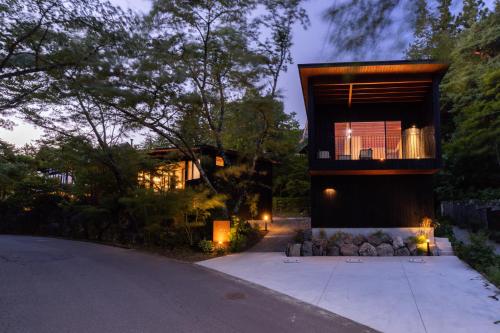 uma casa com uma varanda ao lado de uma entrada em Hotarutei Villas em Yamanouchi