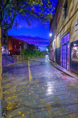 an empty street at night with lights on at dúplex st Pere OnyarapartamentsCom in Girona