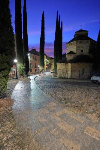 a cobblestone street with a building and trees at night at dúplex st Pere OnyarapartamentsCom in Girona