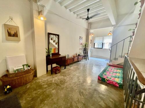 Sala de estar con escalera y espejo en Baan KhaoSoi - Private room in a rooftop hostel 2nd floor, en Khlong San