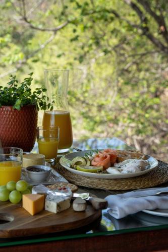 a table with a plate of food and orange juice at Sediba Luxury Safari Lodge in Welgevonden Game Reserve