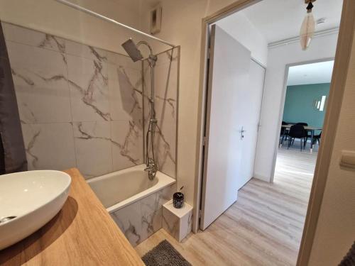 une salle de bain avec un lavabo et une baignoire dans l'établissement Appartement cosy Oloron, aux pieds des Pyrénées et de l'Atlantique!, à Oloron-Sainte-Marie
