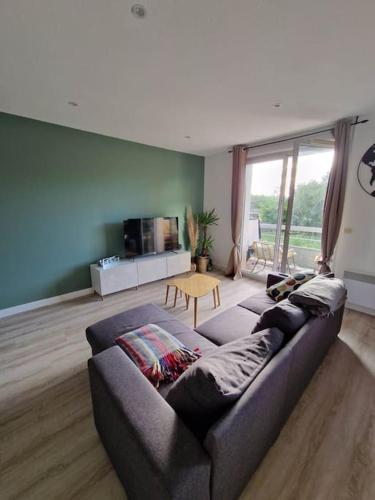 un salon avec un canapé et une table dans l'établissement Appartement cosy Oloron, aux pieds des Pyrénées et de l'Atlantique!, à Oloron-Sainte-Marie