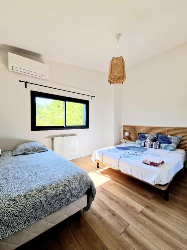 トゥールーズにあるVilla calme grand jardin, à 10mn du centre villeのベッド2台と窓のある寝室