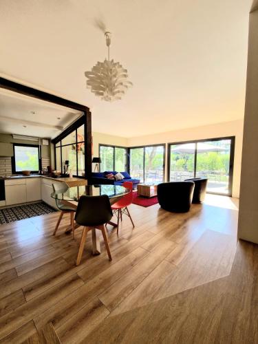 un salon avec une table en verre et des chaises dans l'établissement Villa Piscine, grand jardin, 10mn du centre ville, à Toulouse