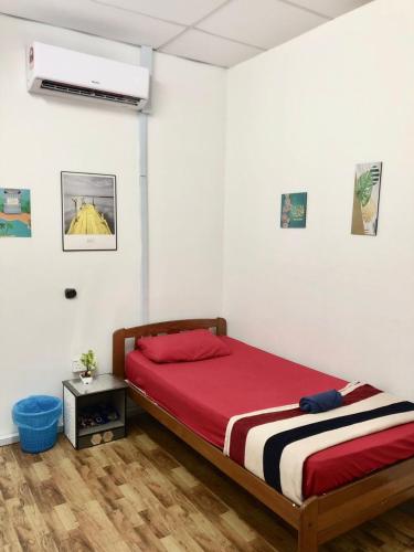 une chambre avec un lit avec une couverture rouge dans l'établissement CZ CLASSIC, à Pasir Puteh