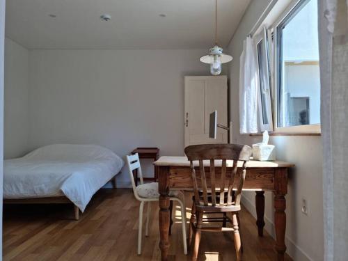 慶州的住宿－B&G House，一间卧室配有一张桌子、两把椅子和一张床