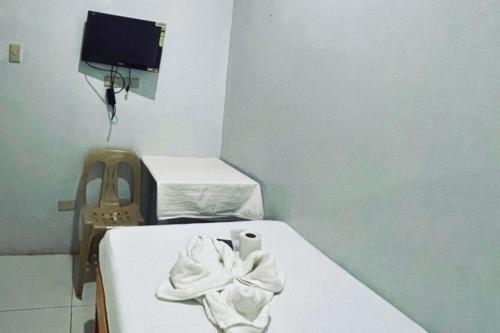 a room with two beds with a towel on the bed at A and A Bed and Breakfast Inn powered by Cocotel in Legazpi