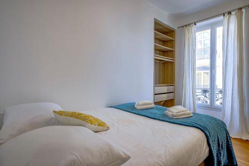 une chambre blanche avec un grand lit avec une fenêtre dans l'établissement Maison Bianchi - Chauvain Place Massena, à Nice