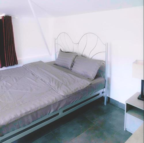 a bed with a metal frame in a bedroom at Du Lịch Lâm Hà - Hồ Gia Trang Villas in Lam Ha