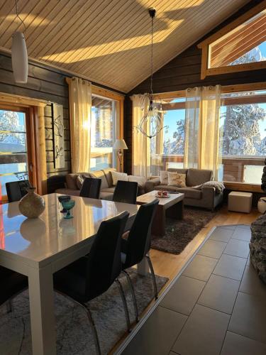 Villa Utsuntuisku في ليفي: غرفة معيشة كبيرة مع طاولة وكراسي