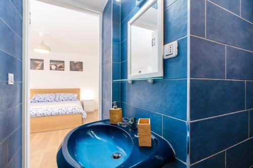 a bathroom with a blue sink and a bedroom at Funzionale e riservato in Venice