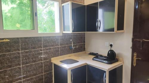 a small kitchen with a sink and a shower at اطلالة الوادي غرفة ساحرة في صامطة in Şāmitah