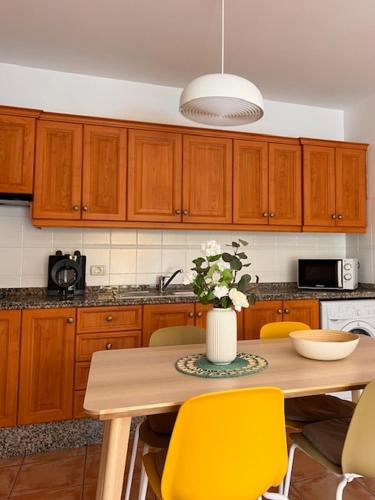 a kitchen with a table with a vase of flowers on it at Holiday in Playa Calera - Swimming pool in Valle Gran Rey