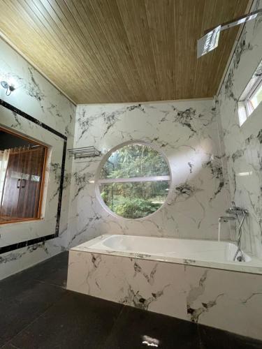ein Bad mit einer Badewanne und einem Fenster in der Unterkunft Rilassare stays cottage in Pedong