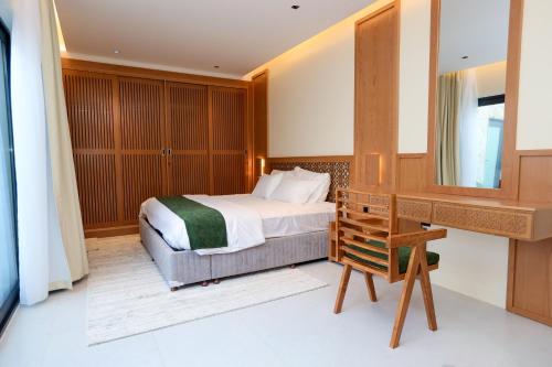 1 dormitorio con cama, escritorio y espejo en Suffah Chalet, en Nizwa
