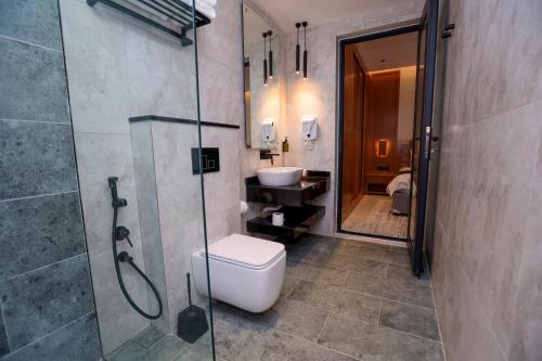 uma casa de banho com um chuveiro, um WC e um lavatório. em Suffah Chalet em Nizwa