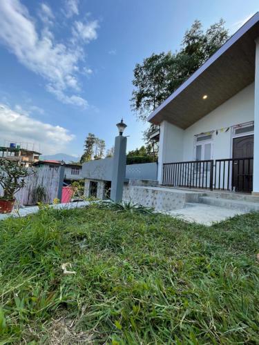 une maison avec une cour herbeuse devant elle dans l'établissement Rilassare stays cottage, à Pedong