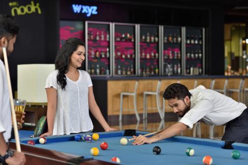 a man and a woman playing pool at a table at Aloft Bengaluru Outer Ring Road in Bengaluru