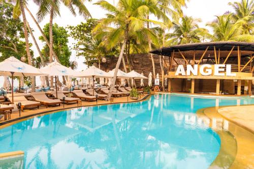 a swimming pool with chairs and umbrellas at a resort at Angel Beach Unawatuna in Unawatuna