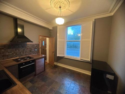 uma cozinha com um fogão e uma janela em Cozy flat near Bedfords Park em Havering atte Bower