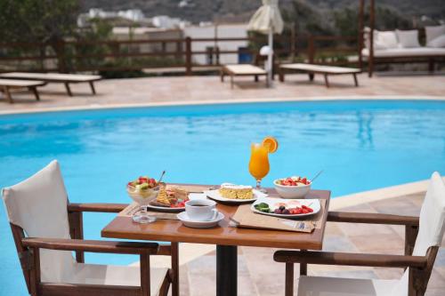 a table with food on it next to a pool at Amorgion Hotel in Katapola
