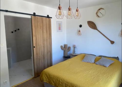 ein Schlafzimmer mit einem gelben Bett und einer Dusche in der Unterkunft La tanière in Les Brugassières