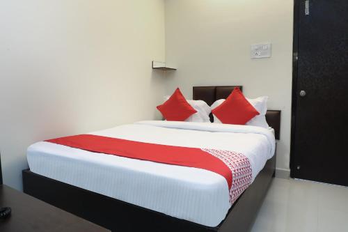 a bedroom with a large bed with red pillows at OYO Way Inn in Kondapur