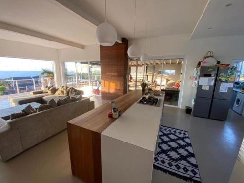 een keuken en een woonkamer met een bank en een koelkast bij Spacious Home with Sea View in Glen Navar in East London