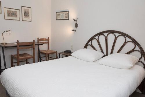 a bedroom with a white bed with two pillows at Cit'Hotel Aéro-Hotel in Le Blanc-Mesnil